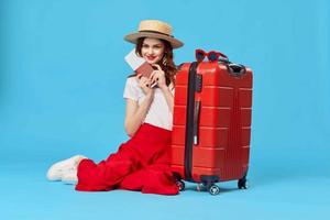 pretty woman tourist wearing hat red suitcase vacation blue background photo