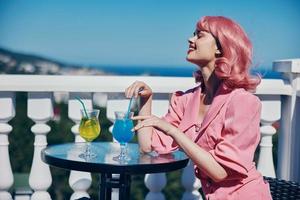 Delighted young girl enjoying a colorful cocktail hotel terrace Relaxation concept photo