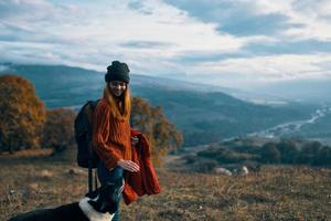cheerful woman hiker nature mountains travel next to the dog freedom friendship photo