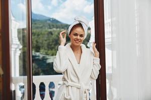 woman with a towel on my head in a white bathrobe staying on the balcony in a hotel unaltered photo