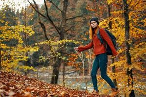 woman in autumn forest near river landscape yellow leaves tourism photo