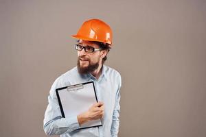 A man in orange paint with documents in hands building an industrial business photo