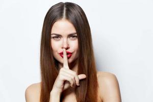 Sexy woman holds his finger near his lips and classified information clear skin Copy space photo