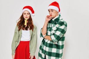 cheerful young couple wearing new year's clothes festive pipes mood photo