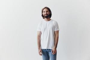 Portrait of a man with a black thick beard and long hair in a white T-shirt on a white isolated background photo