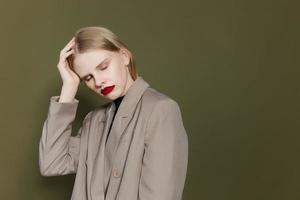 blonde woman with red lips holds hand near face isolated background photo