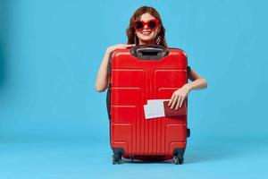 woman with red suitcase sitting on the floor passport and plane tickets lifestyle photo