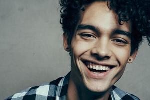 man with curly hair in plaid shirt portrait cropped view model emotions photo