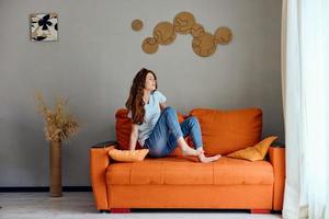 portrait of a woman on the orange couch in the rest room posing unaltered photo