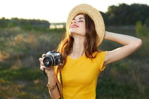 mujer mirando arriba ojos cerrado cámara sombrero amarillo camiseta naturaleza foto