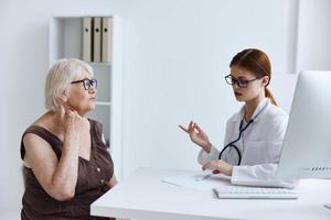 elderly woman with glasses talking to a doctor health complaint photo