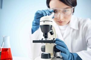 mujer en laboratorio mirando mediante microscopio de cerca biotecnología Ciencias foto