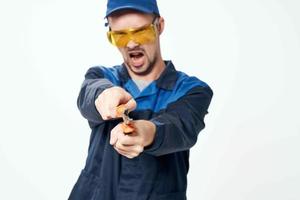 man in construction uniform with pliers in hands repair service photo