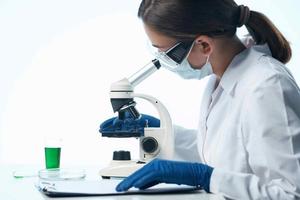 woman scientist looking through a microscope research biology diagnostics photo