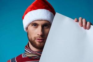 Cheerful man in a santa hat holding a banner holiday isolated background photo