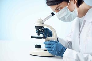 mujer laboratorio asistente médico máscara microscopio diagnósticos biotecnología foto