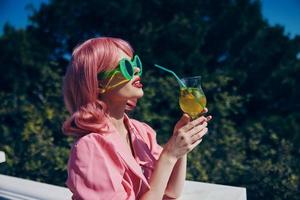 portrait of beautiful woman in pink dress outdoors with cocktail Drinking alcohol photo