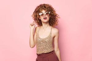 Pretty woman Lips dark glasses curly hair studio pink background photo