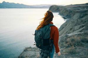 Woman tourist backpack mountains landscape ocean photo