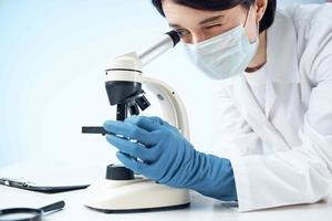 female doctor looking through a microscope biotechnology research laboratory photo