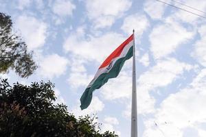 India flag flying high at Connaught Place with pride in blue sky, India flag fluttering, Indian Flag on Independence Day and Republic Day of India, tilt up shot, Waving Indian flag, Har Ghar Tiranga photo