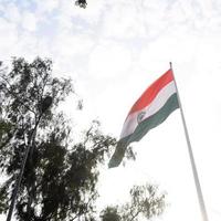 India flag flying high at Connaught Place with pride in blue sky, India flag fluttering, Indian Flag on Independence Day and Republic Day of India, tilt up shot, Waving Indian flag, Har Ghar Tiranga photo