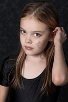 retrato de un pequeño niña con un araña web dibujo en su rostro. foto
