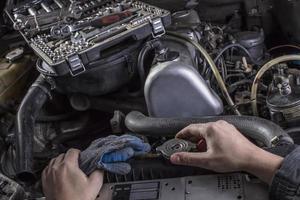 Car engine repair. Engine cooling system services. Hands with a mechanic with a wrench repair Mercedes parts. photo