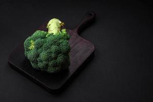 Raw fresh broccoli on a black home kitchen table photo