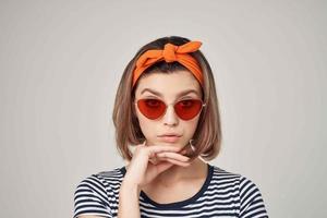 pretty woman in sunglasses with a bandage on her head modern style light background photo