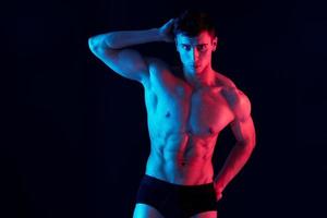 guy with pumped up torso and neon light isolated background athlete model photo