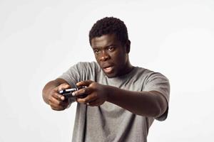 alegre hombre de africano apariencia con un palanca de mando en su manos obras de teatro vídeo juegos foto