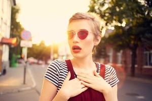 cheerful woman wearing sunglasses outdoors posing lifestyle photo