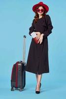 elegant woman in black coat passenger travel lifestyle blue background photo