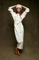 pretty woman in jumpsuit and hat brown boots studio photo