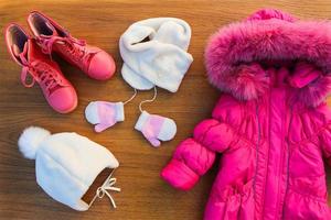 Children's winter clothes warm pink jacket, hat, scarf, mittens, boots photo