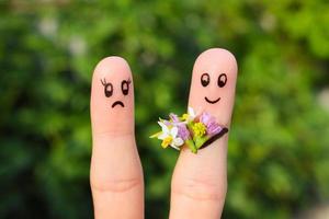 Finger art of couple. Man gives a woman a bouquet of flowers, she is not satisfied. photo