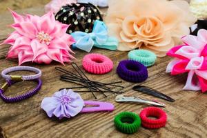 Different hair clips on wooden background photo