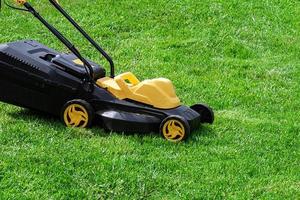 electric grass mower trimming green lawn photo