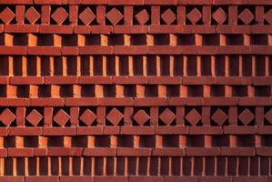 Red brick wall with ornamental pattern in shadow and light gradient photo