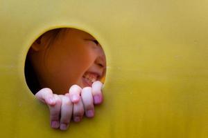 Asian little girl enjoys playing at playground photo