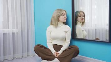 Unhappy depressed young woman looking at herself in the mirror. video