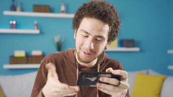 Phone addicted young male student starts to study at home, he thinks that he has to study. video