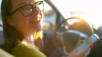 femme dans des lunettes en utilisant une téléphone intelligent dans le voiture video