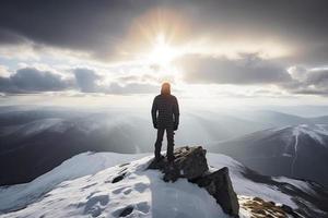 hombre en pie en el parte superior de un nevado montaña cima. panorámico ver foto