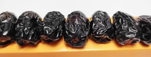 Close up of dried ajwa dates on a box isolated on white background photo