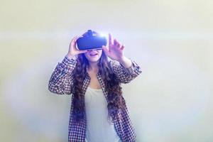 sonrisa joven mujer vistiendo utilizando virtual realidad vr lentes casco auriculares en blanco antecedentes. teléfono inteligente utilizando con virtual realidad gafas de protección. tecnología, simulación, de alta tecnología, videojuego concepto. foto