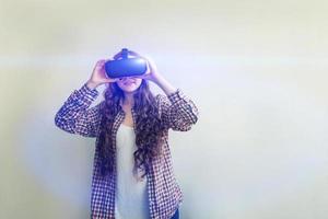 sonrisa joven mujer vistiendo utilizando virtual realidad vr lentes casco auriculares en blanco antecedentes. teléfono inteligente utilizando con virtual realidad gafas de protección. tecnología, simulación, de alta tecnología, videojuego concepto. foto