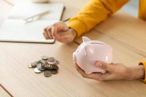 Saving money investment for future. Female woman hands holding pink piggy bank and putting money coin. Saving investment budget business wealth retirement financial money banking concept. photo