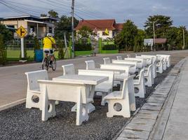Views of rows of white marble tables and chairs lined up on the paved stone floor paved a way. photo